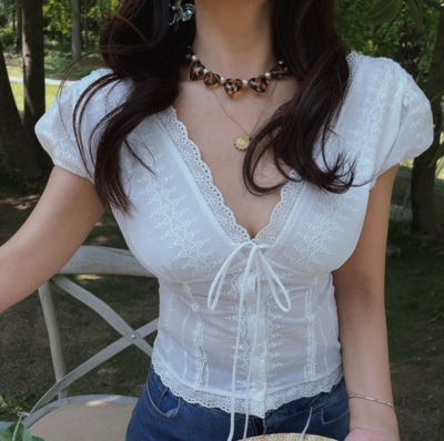 White lace V-neck top with ties on the chest