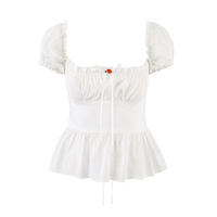 White short-sleeved shirt with lace trim, bow tie detail, and button closure. - Thumbnail 1
