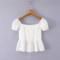 White short-sleeved shirt with lace trim, bow tie detail, and button closure. - Thumbnail 3