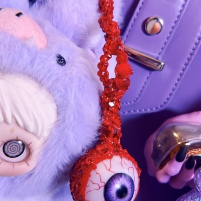 Purple plucked eye bag charm