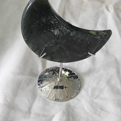Volcanic moss green hand carved moon agate quartz on a stand