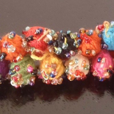 Orange thread pom pom bracelet