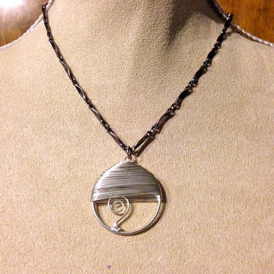 Silver wrap pendant on black chain