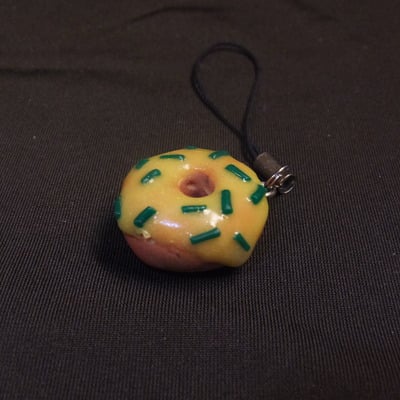 Yellow frosting and green sprinkle doughnut