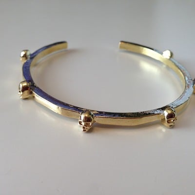 Multiple skull bangle in gold