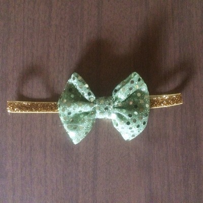 Green sequin bow on gold elastic