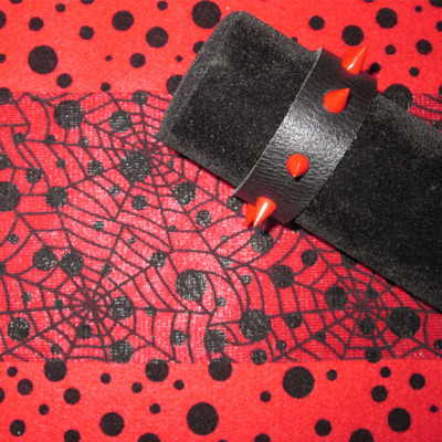 Black leather bracelet with red spikes