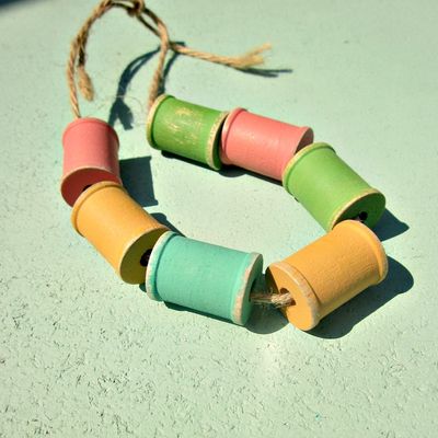 Set of 7 distressed wooden spools in pastel colors