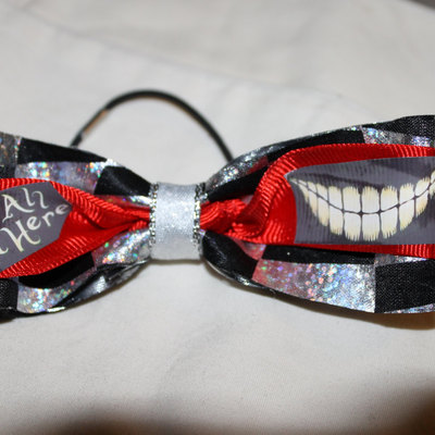 "we're all mad here" cheshire cat grin- 2 in black & silver ribbon with a red center  cheer bow