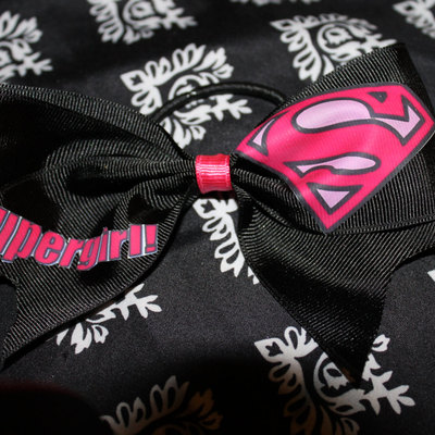 "supergirl" cheer bow; 2 in black grosgrain ribbon with a hot pink center
