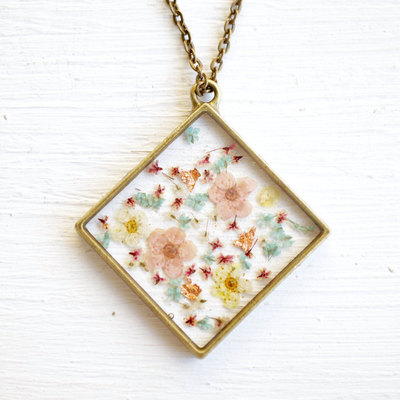 Real pressed flower and resin necklace in magenta, pastel pinks, yellows, and blues mix, with real gold foil flakes.