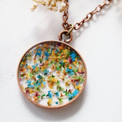 Real pressed flower and resin necklace in oranges, yellows, greens, blues, and pinks