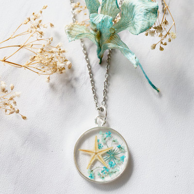 Real starfish and pressed flower in resin necklace in blues mix