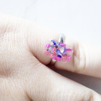 Real pressed flower and resin ring in reds, purples, pinks, and white