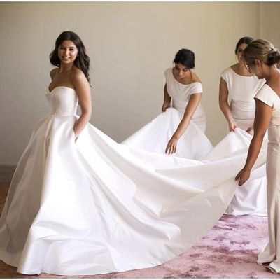 Strapless sweetheart satin ball gown wedding dress featuring long train and side pockets